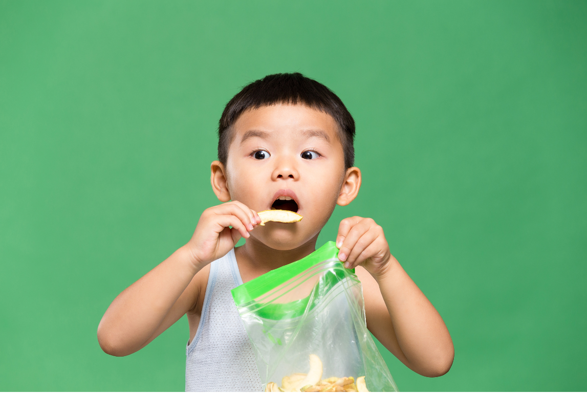 Anak mengonsumsi snack kemasan